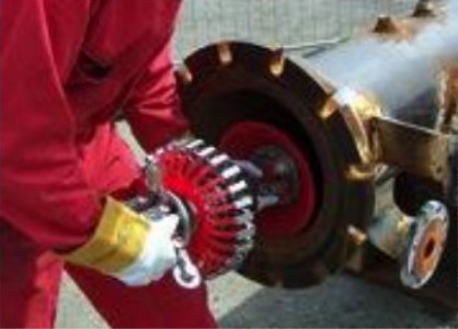 Technician handling an in-line inspection tool at a pipeline launcher.
