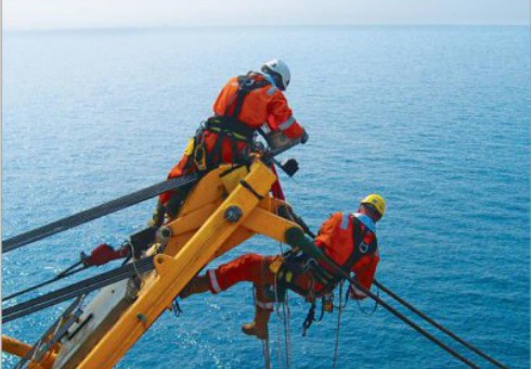 Rope-access technicians working on an offshore structure.